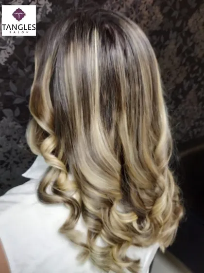 This is our hero item. A perfect example of a sun-kissed, golden blonde balayage. We achieved this look by hand-painting highlights to create a seamless, natural gradient, finished with soft curls to enhance the dimension and shine.