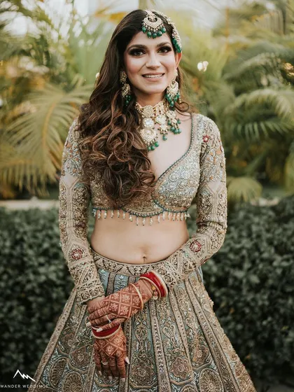 A happy, smiling portrait of the bride outdoors. The natural light shows off her glowing skin and the beautiful details of her makeup.