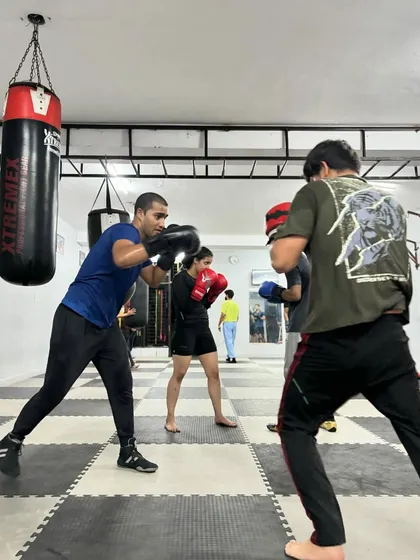 A dynamic shot from our Thursday session, with multiple students engaged in pad work and drills. The gym is alive with focused activity.