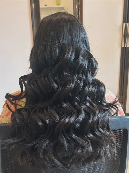 A full view of classic, voluminous curls. This timeless hairstyle is perfect for any special occasion, adding glamour and movement.