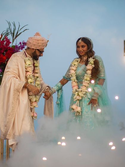 A magical wedding moment. The bride's soft curls look ethereal as she makes her entrance through the smoke.