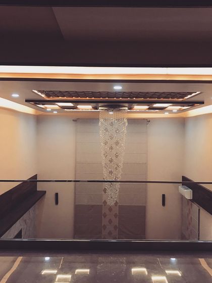 A duplicate of image 70, this view from the upper level emphasizes the symmetry and elegance of the double-height space and its luxurious lighting feature.