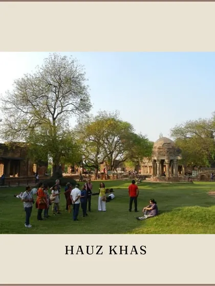 A group gathers on the lawns of Hauz Khas, with the tomb complex in the background. The area is a perfect example of how medieval ruins have been integrated into modern urban life.