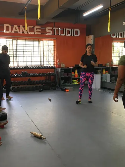 A master trainer demonstrates foot mobility exercises using simple tools like a tennis ball and a rolling pin.