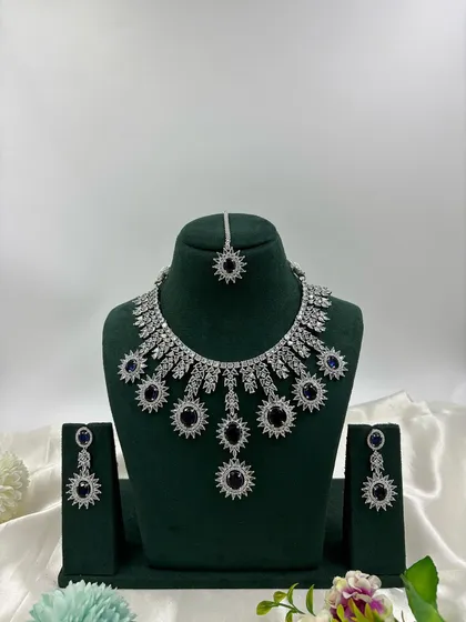 Showcasing the modern side of our collection, this silver-plated American Diamond set features a unique sunburst design. It's available in multiple stone colors including white, black, and mint green, perfect for cocktail parties and contemporary tastes.