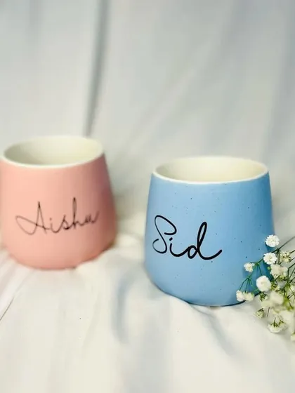 Matching pastel mugs, personalized for the happy couple. These are a popular item in our anniversary and wedding hampers.