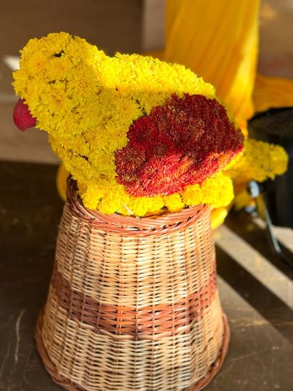 A creative floral sculpture of a parrot, made entirely from yellow and red flowers. This kind of custom floral art adds a playful and memorable touch to the decor.