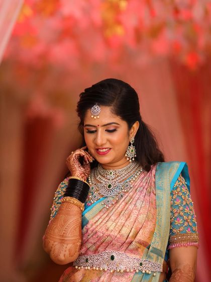 Rashmi looks stunning for her reception in a peach and blue Kanchipuram saree. Her makeup is soft and glamorous, with a focus on glowing skin and beautifully defined eyes.