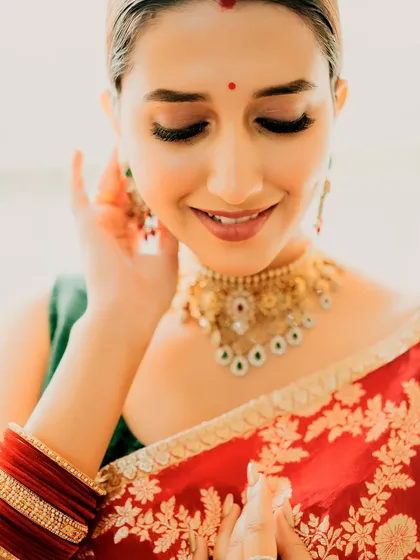 A close-up on the soft, classic makeup that complements the traditional red saree.
