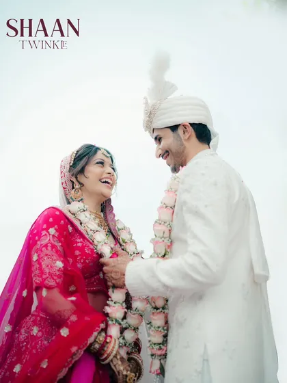 Laughter and love during the varmala. This candid shot captures the couple's happy interaction, a memory that truly reflects their personalities.