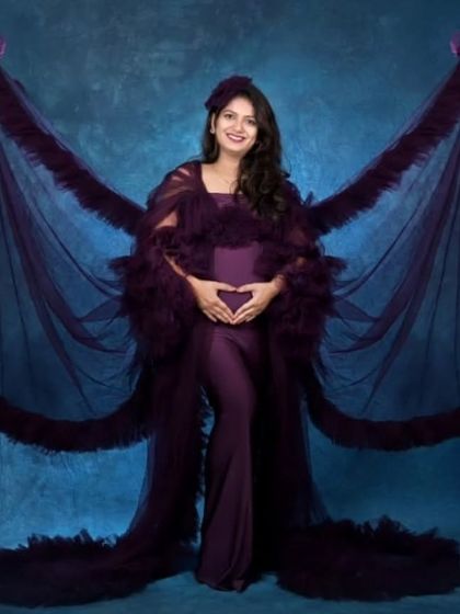 Like a beautiful butterfly. This wine-colored gown features dramatic ruffled wings that create a unique and artistic silhouette for a studio maternity photoshoot.