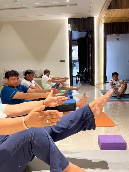 A group practicing Navasana (Boat Pose) to build core strength. I use props like yoga blocks to help students maintain correct form.