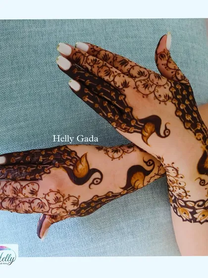 A unique take on the peacock theme. The birds are created with negative space, and their bodies flow elegantly from the wrist to the fingers.