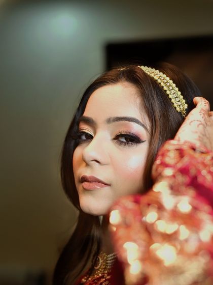 A close up shot focusing on the stunning makeup and traditional Kashmiri jewelry. The intricate details of the outfit and the flawless makeup work together to create a regal look.