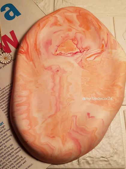 The beautiful orange and pink marble pattern of our oval cloud tray, shown without any items to highlight the design.