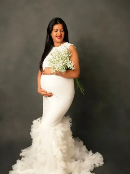 A beautiful portrait in our white mermaid gown with a ruffled train, holding a bouquet of baby's breath.