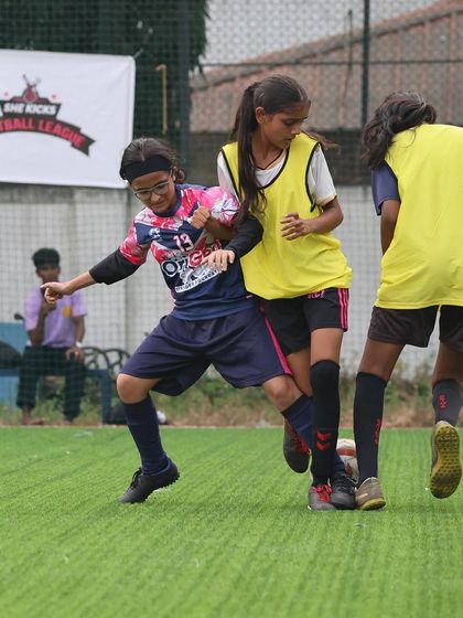 A close-up action shot of our player's determination and strength as she competes for the ball in a crowded space.