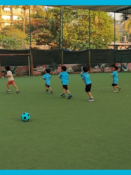 Look at them go! Our little athletes are running across the field during a warm up game. We start every session with activities that get their energy up and ready for a fun day of football.