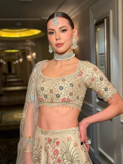 A Parisian beauty looking resplendent in Indian couture. The makeup is sculpted and luminous, with a clean, sharp finish that gives a high-fashion, almost editorial feel to her bridal look.