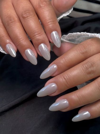 A classic and elegant pearl chrome finish on long almond nails. This look is timeless and sophisticated, perfect for any occasion.