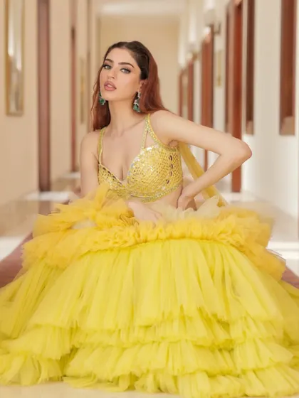 A playful and dramatic shot of the tiered yellow ruffle lehenga from Liz Paul. This outfit is all about making a fun and fashionable statement.