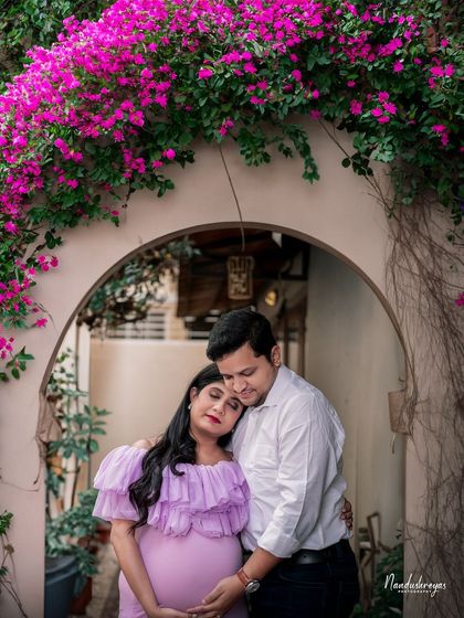An embrace that says everything. This couple's portrait under a floral arch is the essence of romance and anticipation.