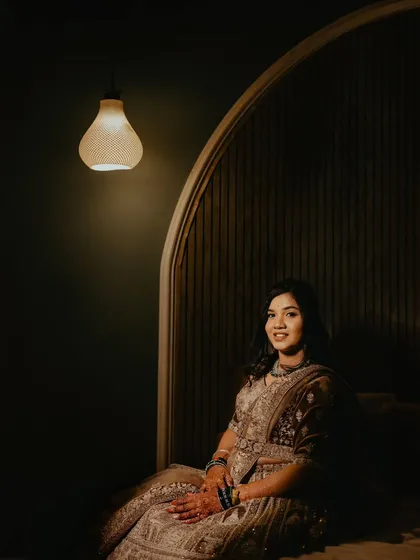 A quiet, elegant portrait of the bride, beautifully lit by a single pendant lamp, creating a moment of calm during the reception.