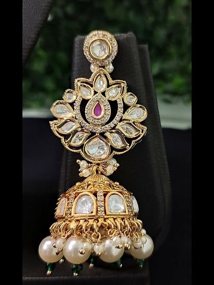 The matching jhumka earring, featuring a floral kundan top and a pearl-adorned bell.