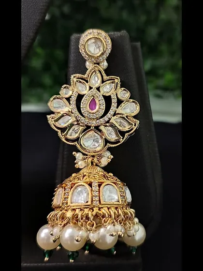 The matching jhumka earring, featuring a floral kundan top and a pearl-adorned bell.