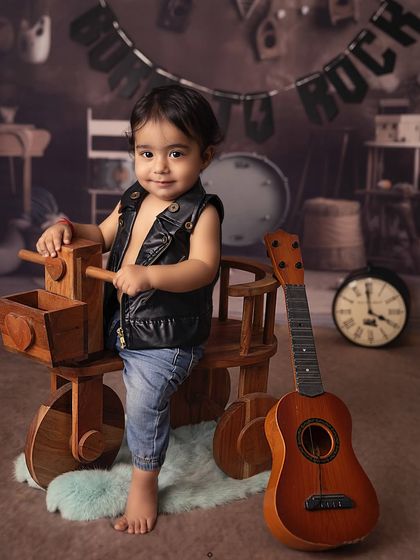 Born to rock! With a leather vest and a cool stance next to his guitar, this little rockstar is ready for his first concert. Themed sessions like this are all about capturing personality.