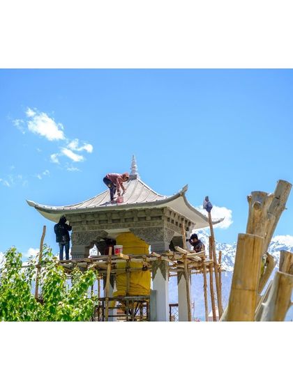 Workers carry out renovations on a stupa, showing the continuous effort to preserve these sacred structures.