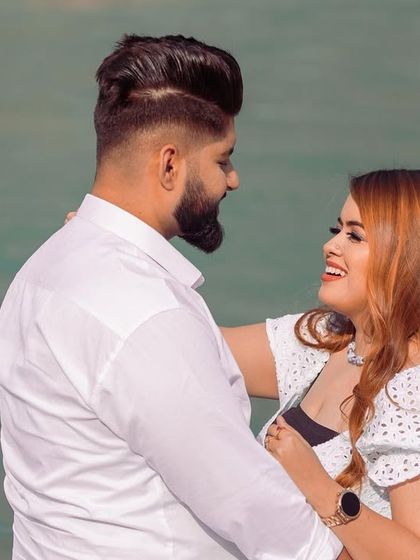A happy and loving close-up of the couple by the water, capturing a genuine moment of joy.