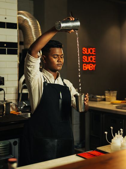 Shaking up the 1920s vibe with every cocktail at my events. A bartender pours a drink with focus and flair.