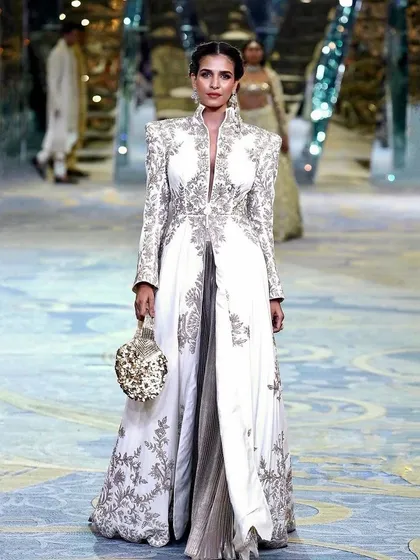 A full runway look from a Manish Malhotra bridal couture show. I created a powerful yet elegant look with a clean, structured updo and makeup that highlighted the model's features, ensuring she looked majestic under the bright lights of the fashion show.
