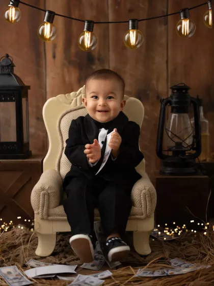 A joyful shot of a baby boy in a tuxedo, looking absolutely thrilled during his "Boss Baby" themed session.