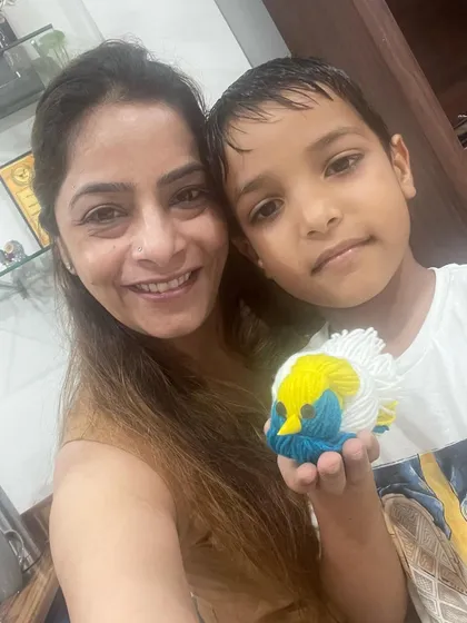 So much creativity in one picture! This student proudly holds up the colorful fish he made during our hands on arts and crafts activity.