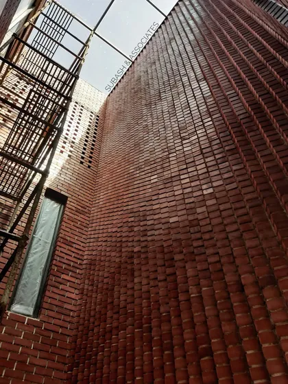 Our expertise in material craftsmanship is demonstrated in this double-height brick wall. The unique, undulating pattern interacts with natural light from the skylight above, creating a textured, warm surface that transforms a simple wall into a piece of architectural art.