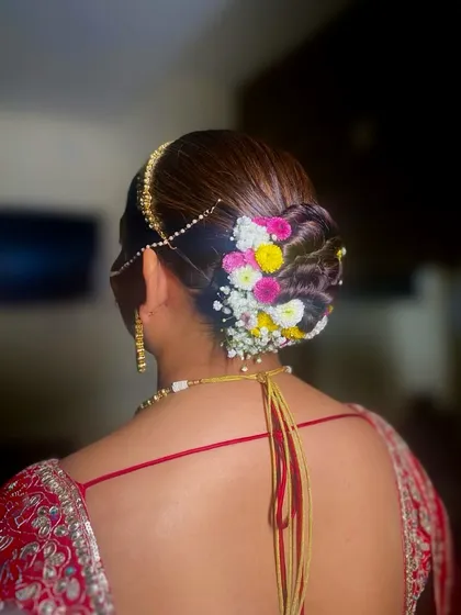 This side view shows how a matha patti can be perfectly integrated with a floral bun for a complete, traditional bridal look.