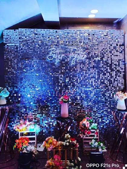 A beautiful floral setup against a blue sequin wall. The "Better Together" neon sign makes it a perfect photo booth for celebrating a couple's journey.