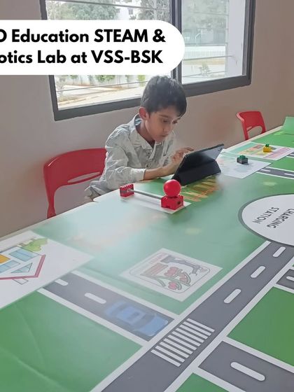 A student at our LEGO Education STEAM & Robotics Lab at Vidyashilp School, Banashankari (VSS-BSK), uses a tablet to program his creation on the city-themed mat, learning coding through playful storytelling.