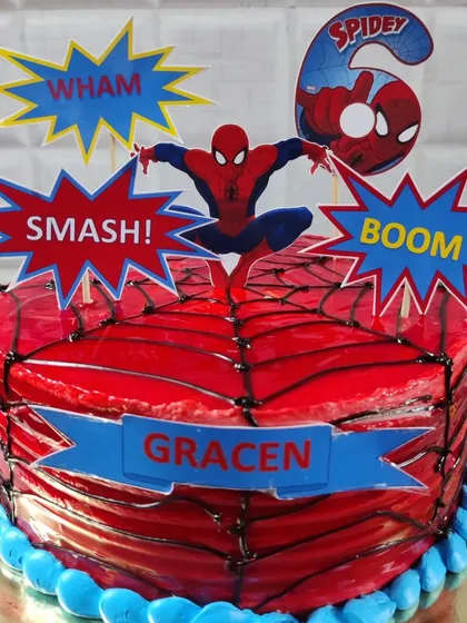 An action-packed Spider-Man cake for a 6th birthday. This design features a glossy red web effect and comic book style toppers for your little superhero.