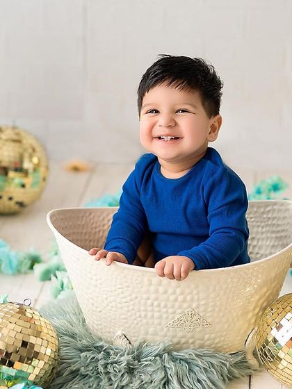 The most infectious smile! This happy baby is having a great time in his sitter session, surrounded by fun props and bright colors.