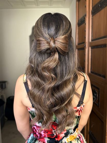 A creative and cute half-up style featuring a bow made entirely from the bride's own hair.