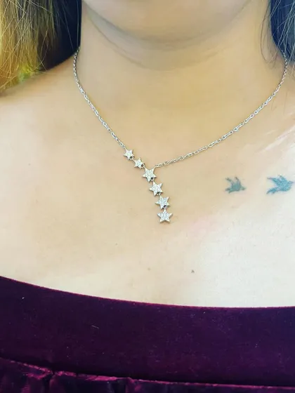 A close-up of the beautiful star-themed silver necklace from Giva, perfectly complementing my festive velvet top.