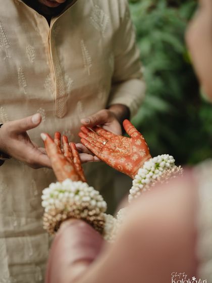 A beautiful close-up of the bride showing her henna-adorned hands to the groom. A moment of shared admiration for a beautiful tradition.