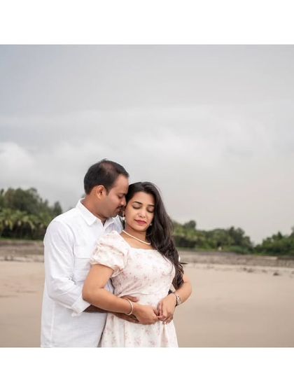 A romantic embrace on the beach, with a beautiful reflection in the wet sand creating a stunning visual.