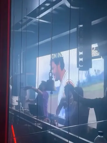 A view of my DJ booth from outside, with my visuals playing on the screen. It shows how I'm at the center of the party's audio-visual experience.