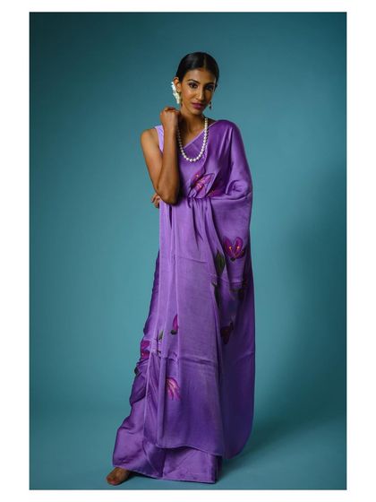 A classic, poised stance in a beautiful purple saree. This shot is perfect for showcasing the overall look and feel of the garment for a fashion catalog.
