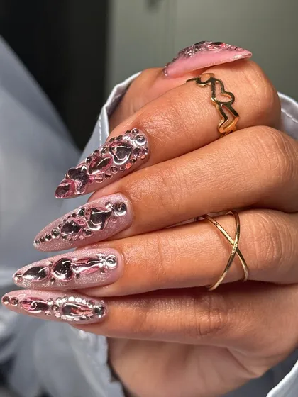 A side profile of the stiletto nails, showing the raised texture of the chrome hearts. This is a perfect example of how I can turn a nail set into a piece of wearable art.