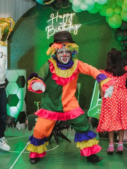 A colorful clown dances with the kids at a football-themed birthday party. My entertainers are experts at getting everyone involved and keeping the energy high.